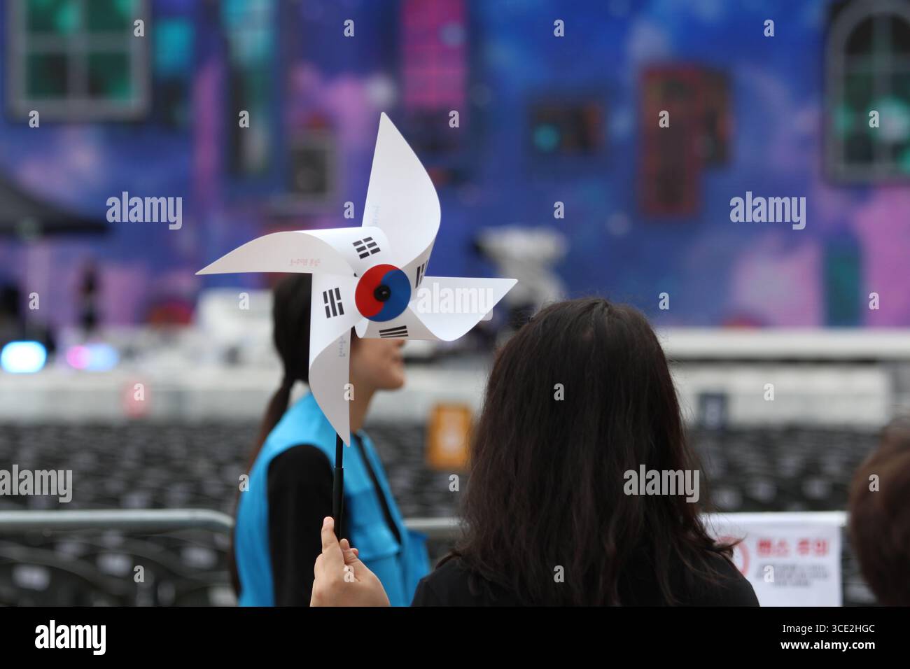 Seoul, Corea del Sud. 15 agosto 2025. Una donna tiene in mano un mulino a vento di carta con la bandiera coreana mentre celebra il giorno della Liberazione Nazionale della Corea al Seoul Plaza. Crediti: Daniyar Atadjanov/Alamy Live News Foto Stock
