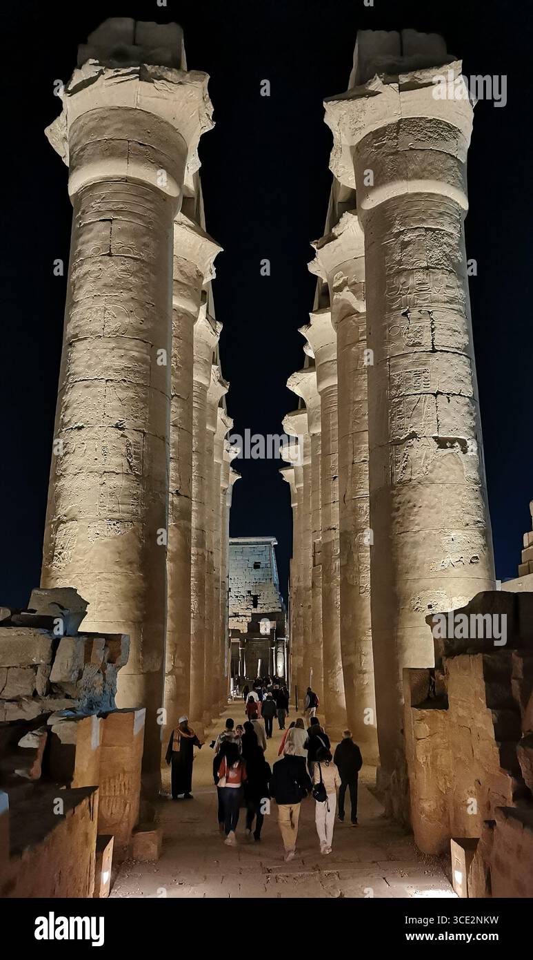 Il Colonnato di Amenofi III al Tempio di Luxor illuminato di notte, Luxor, Egitto. I visitatori appaiono nani sotto enormi colonne di arenaria. - Immagine stock catturata con smartphone