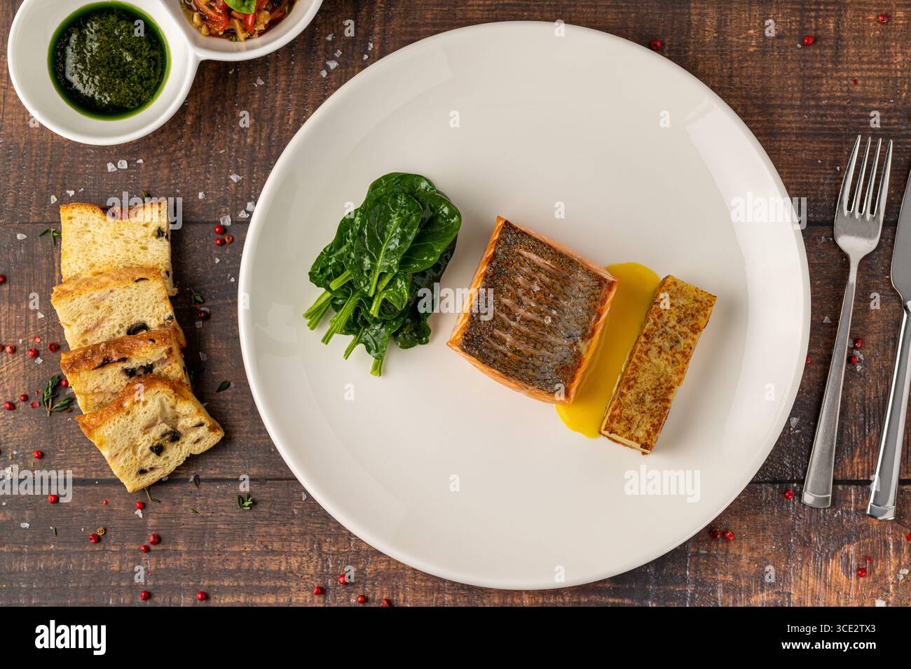 Filetto di salmone scottato servito con spinaci saltati e croquette di patate Foto Stock