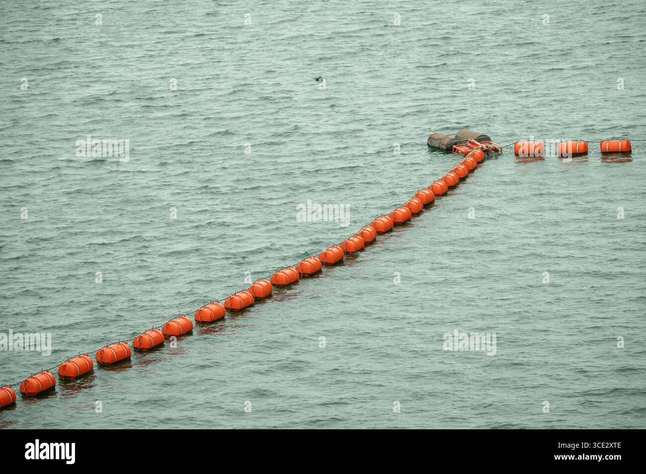Boe di sicurezza arancioni che galleggiano sulla superficie dell'acqua nel porto marino. Marcatori per la navigazione nautica per la sicurezza delle imbarcazioni e della navigazione marittima. Marcatori di sicurezza Foto Stock