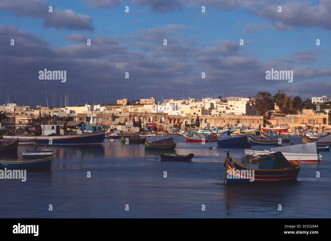 Malta. Marsaxlokk. Edifici sul lungomare e porto. Foto Stock