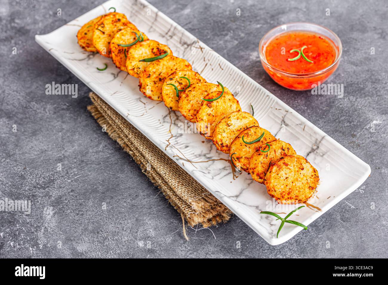 Patate fritte a spicchi con condimento e rosmarino Foto Stock