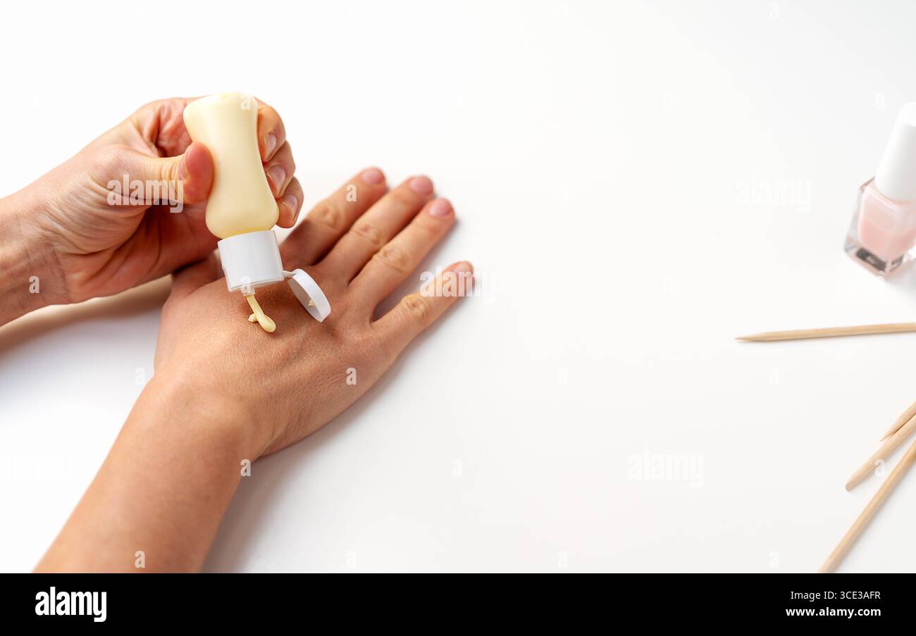 Primo piano della mano con applicazione di crema nutriente Foto Stock