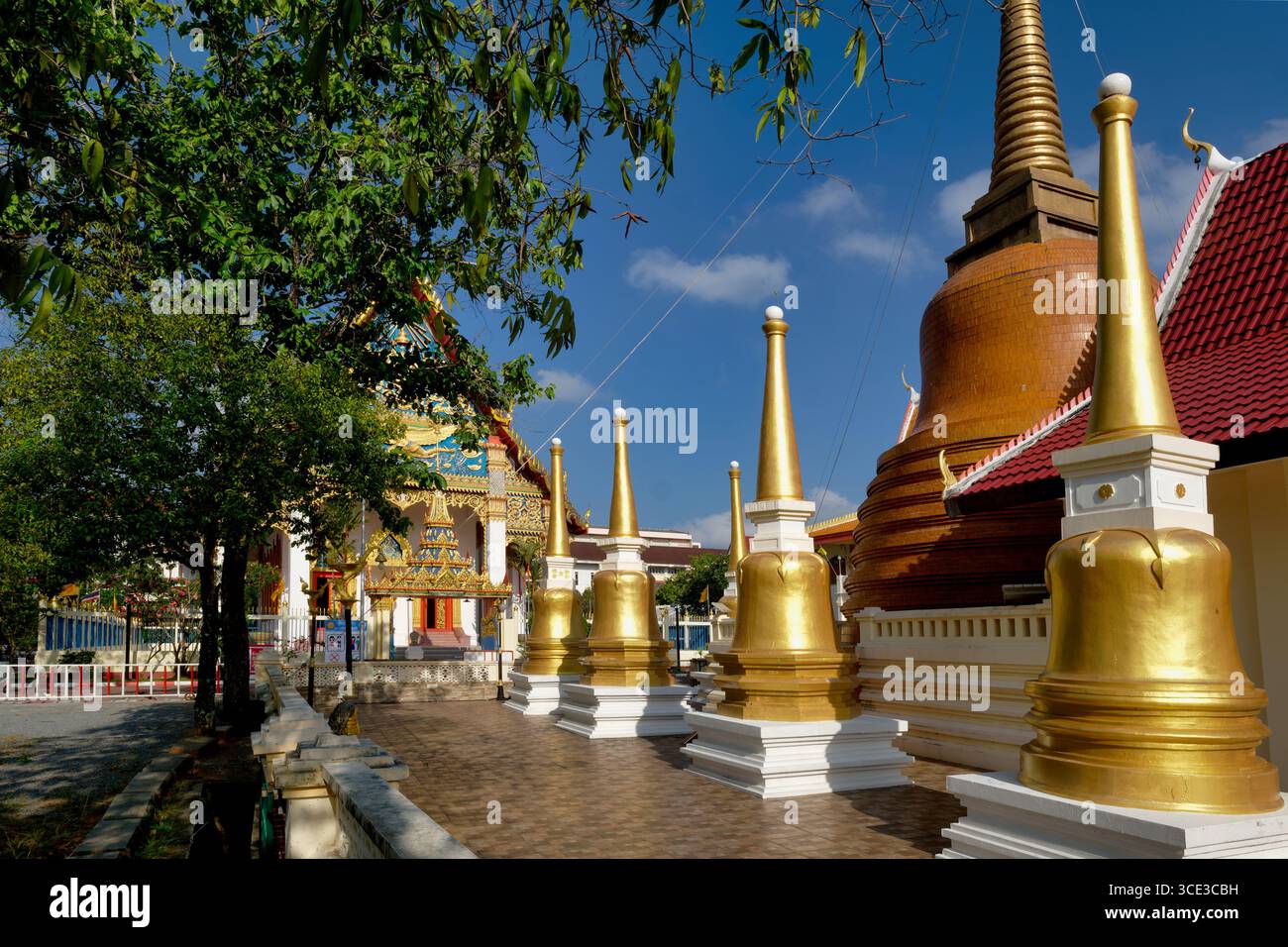 Una fila di cedri dorati (stupa) nei terreni di Wat Mongkon Nimit (Wat Phuttha Mongkon), Phuket Town, Phuket, Thailandia Foto Stock
