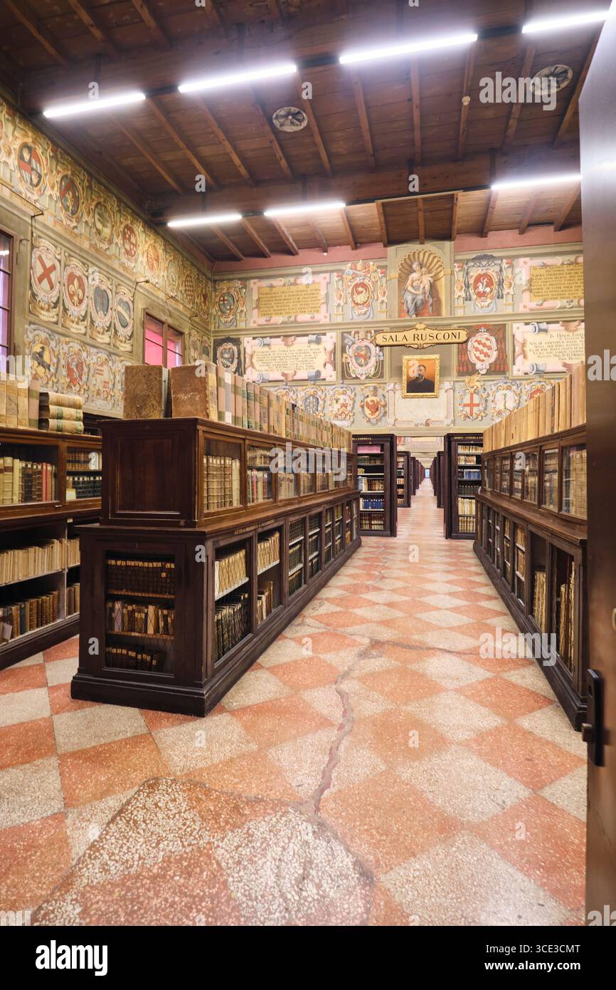 Vista della sezione pile, libri e scaffali. Iconiche custodie in legno scuro. Presso la Biblioteca Comunale dell'Archiginnasio di Bologna. Foto Stock