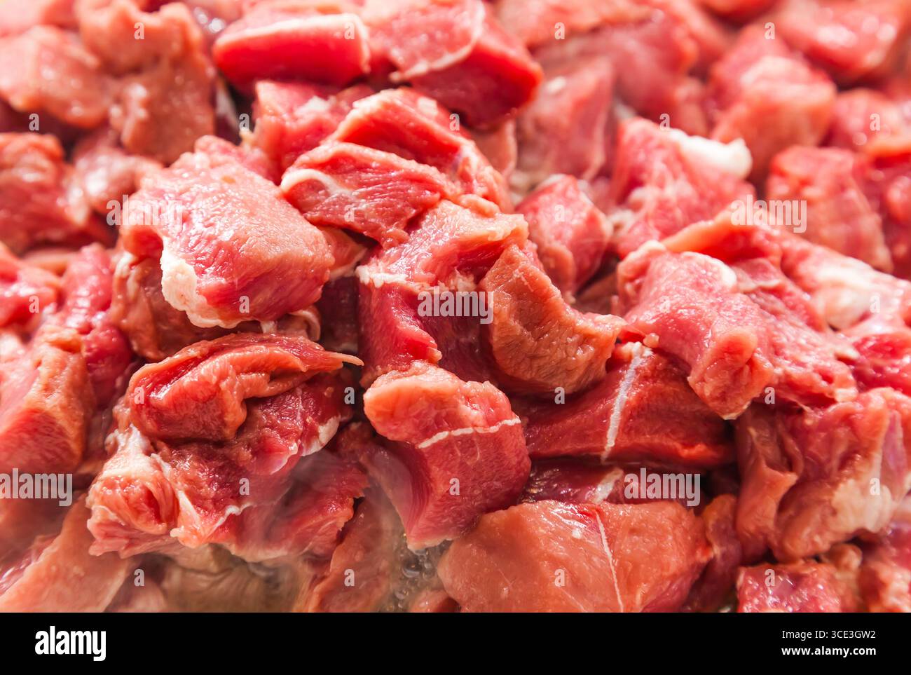 Pezzi a dadini di arrosto di manzo crudo, primo piano. Foto Stock