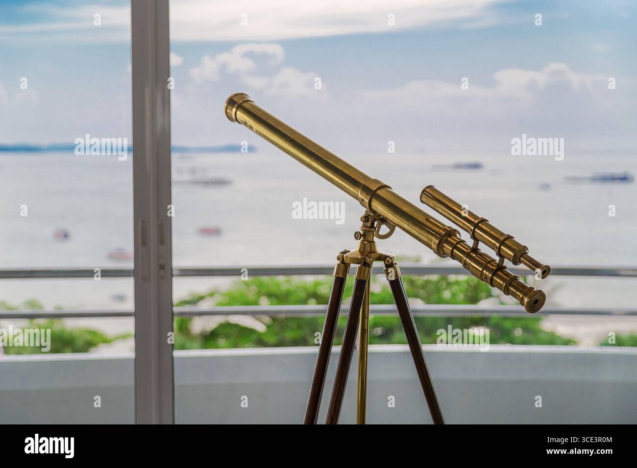 Telescopio in ottone d'epoca su un treppiede presso il punto panoramico del balcone che si affaccia sull'oceano, piccola profondità di campo. Foto Stock