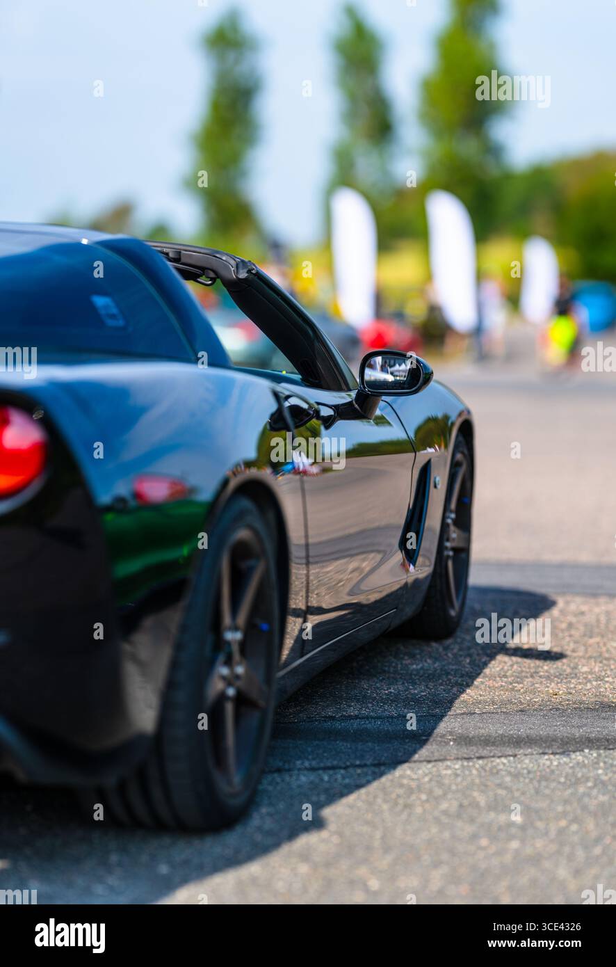 Specchietto laterale di un'auto sportiva nera veloce Foto Stock