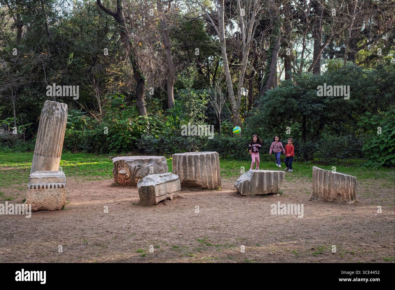 Bambini che giocano tra i resti archeologici nei Giardini nazionali di Atene, Grecia Foto Stock