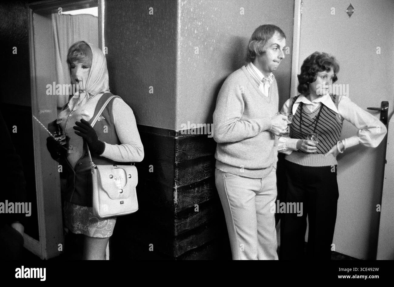 Caching Night o NEET Dungworth, Sheffield, Yorkshire 1974. Royal Hotel Dungworth, in realtà il pub locale, ma con un nome grandioso. Una tradizione locale annuale associata all'All Souls Day di novembre. Due abitanti del posto e una donna "Caker" si nascondono sotto mentite spoglie. (Un uomo vestito con una maschera e indossa i vestiti di una donna.) Inghilterra 1974 Regno Unito 1970s HOMER SYKES. Foto Stock