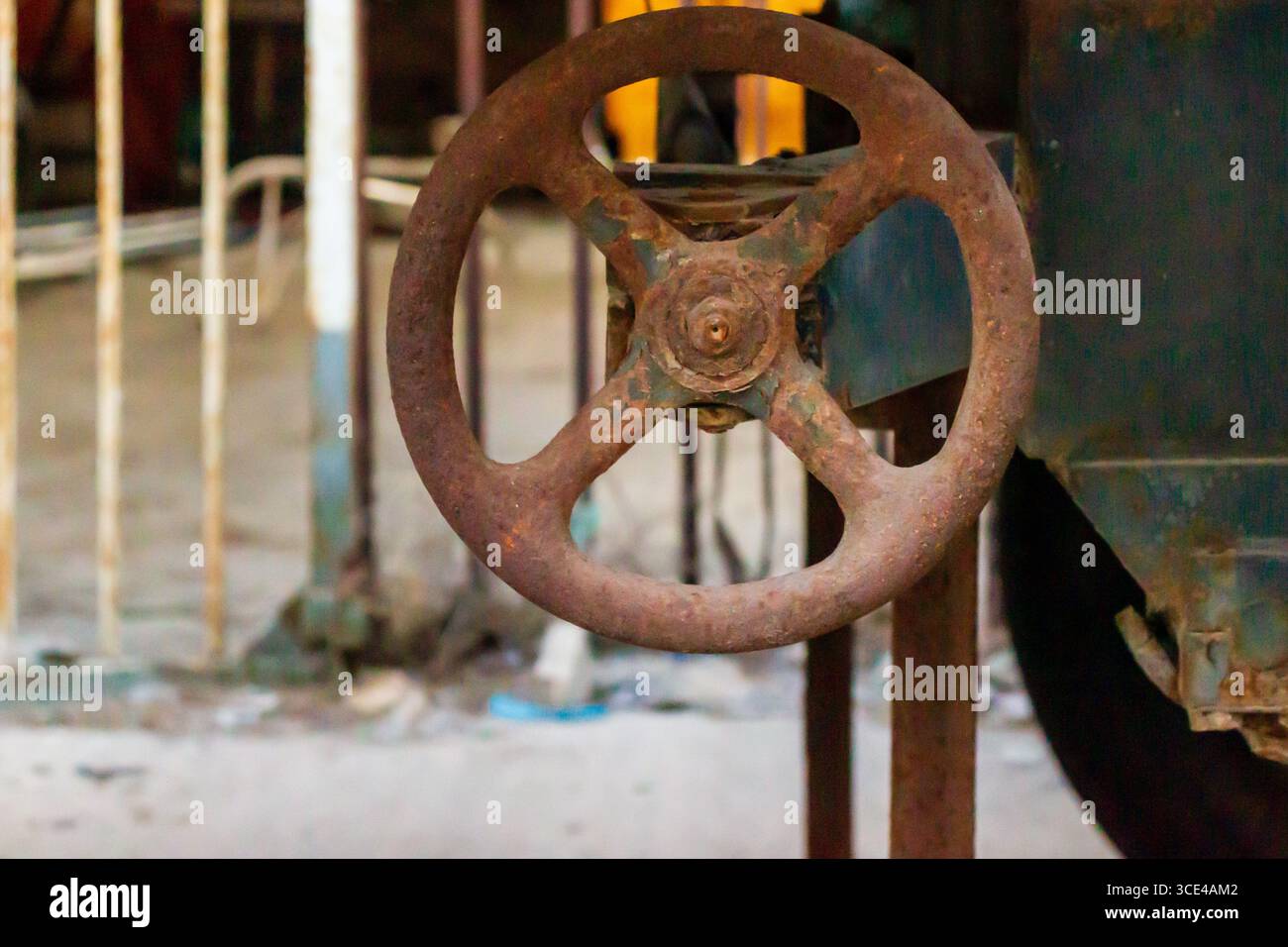 Ruota per valvole industriali Rusty in fabbrica con struttura metallica resistente agli agenti atmosferici Foto Stock