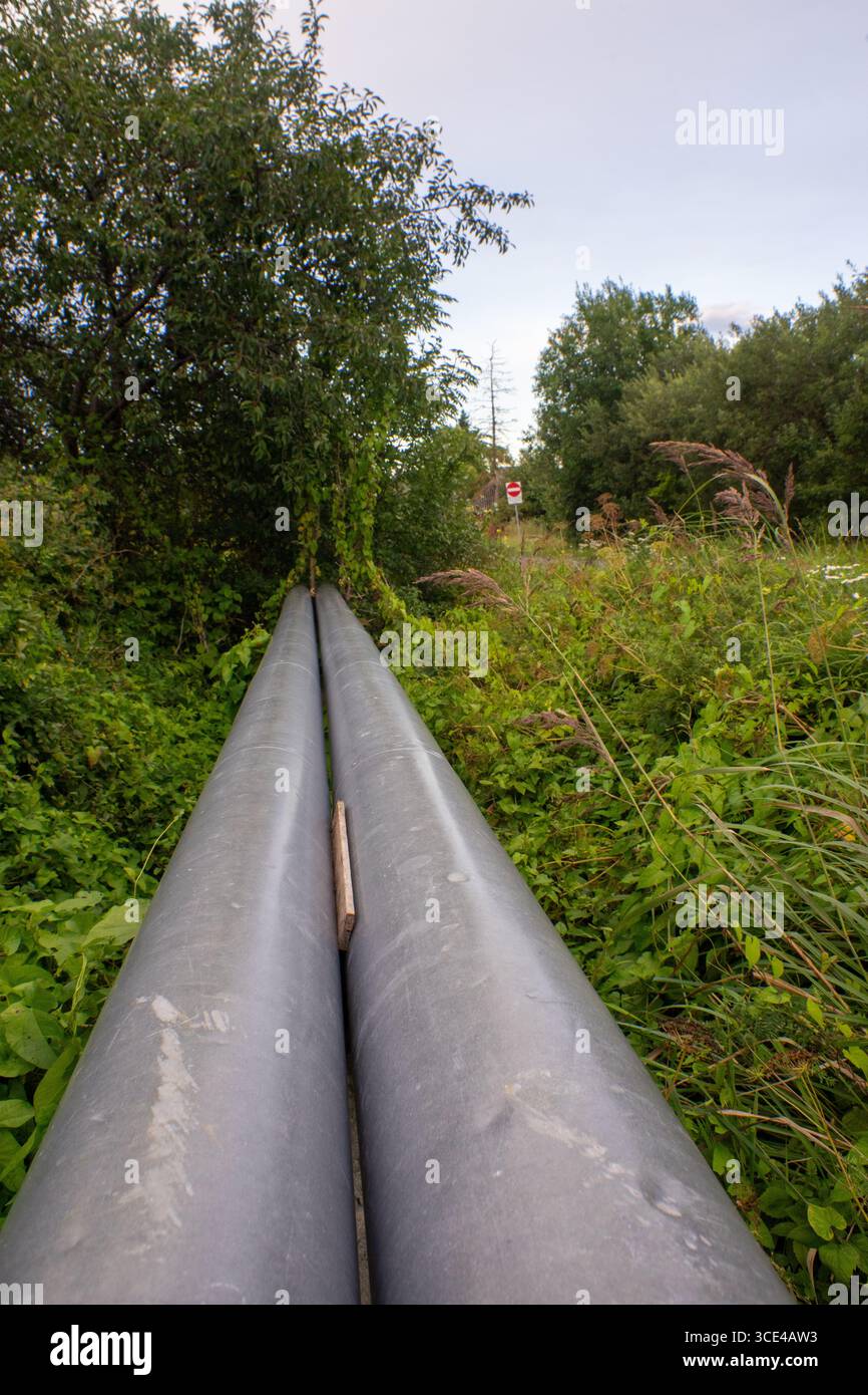 Due tubi di riscaldamento paralleli che attraversano il campo erboso. Foto Stock