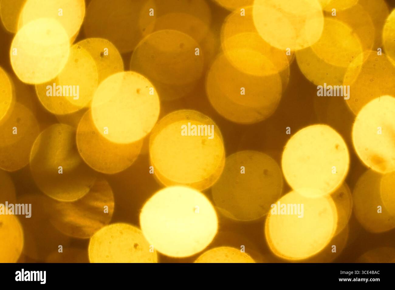 I cerchi bokeh dorati creano uno sfondo astratto. Sfondo romantico, perfetto per la serata di un appuntamento, l'invito al matrimonio, i temi dell'amore e della celebrazione Foto Stock