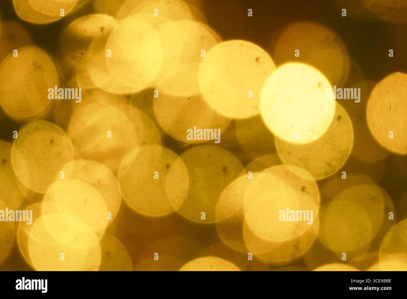 Caldo bokeh dorato: Sfondo meditativo, atmosfera consapevole, terapia con luce soffusa. Relax e benessere. Cerchi di luce dorati terapeutici Foto Stock