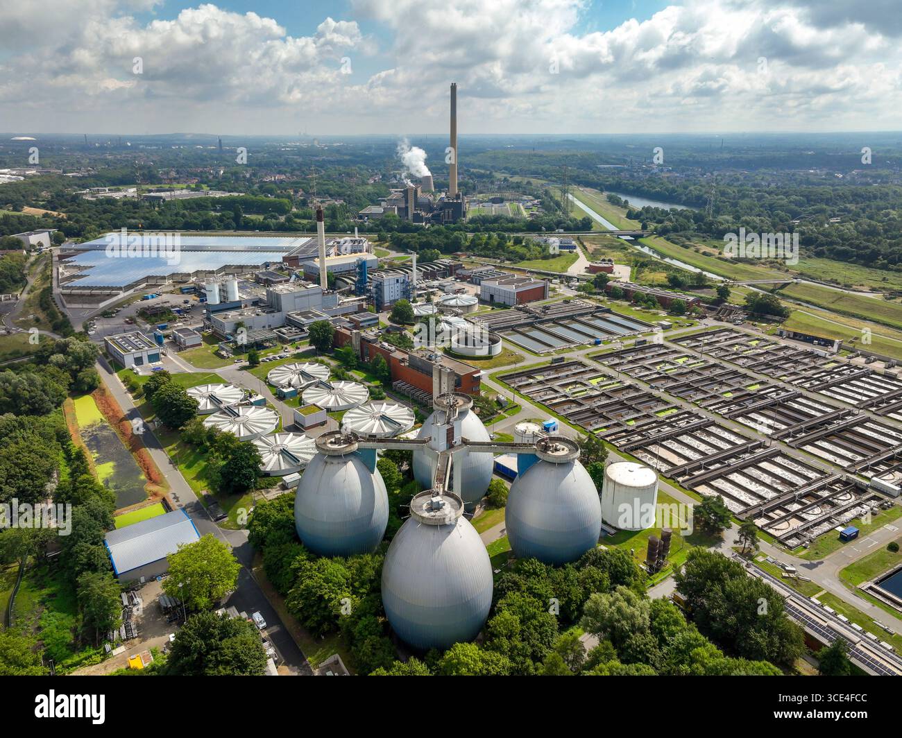 Bottrop, Nordrhein-Westfalen, Deutschland - Industrielandschaft im Ruhrgebiet, vorne die Emschergenossenschaft Kläranlage Bottrop am Fluss Emscher, hinten Müllheizkraftwerk Essen-Karnap RWE Generation se. Abwasserreinigung in der Klaeranlage Bottrop, Die erste Reinigungsstufe einer Klaeranlage umfasst die mechanische Reinigung Entfernung grober Feststoffe, sabbia, Fette, Die zweite Stufe den biologischen Prozess Entfernung von Naehrstoffen mittels Mikroorganismen, die Stufe den biologischen, die Stufe-wifat Befat Befat Befalifat fat fat fat fat fung Physifat Befung Physifat Befung. Kuenftig wird eine vierte Reinigungsstufe zu Foto Stock