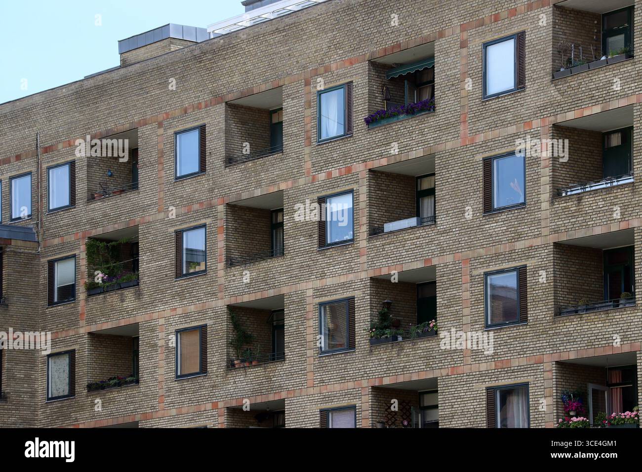 Parte di un moderno edificio di appartamenti in mattoni con finestre e balconi (Copenhagen, Danimarca) Foto Stock