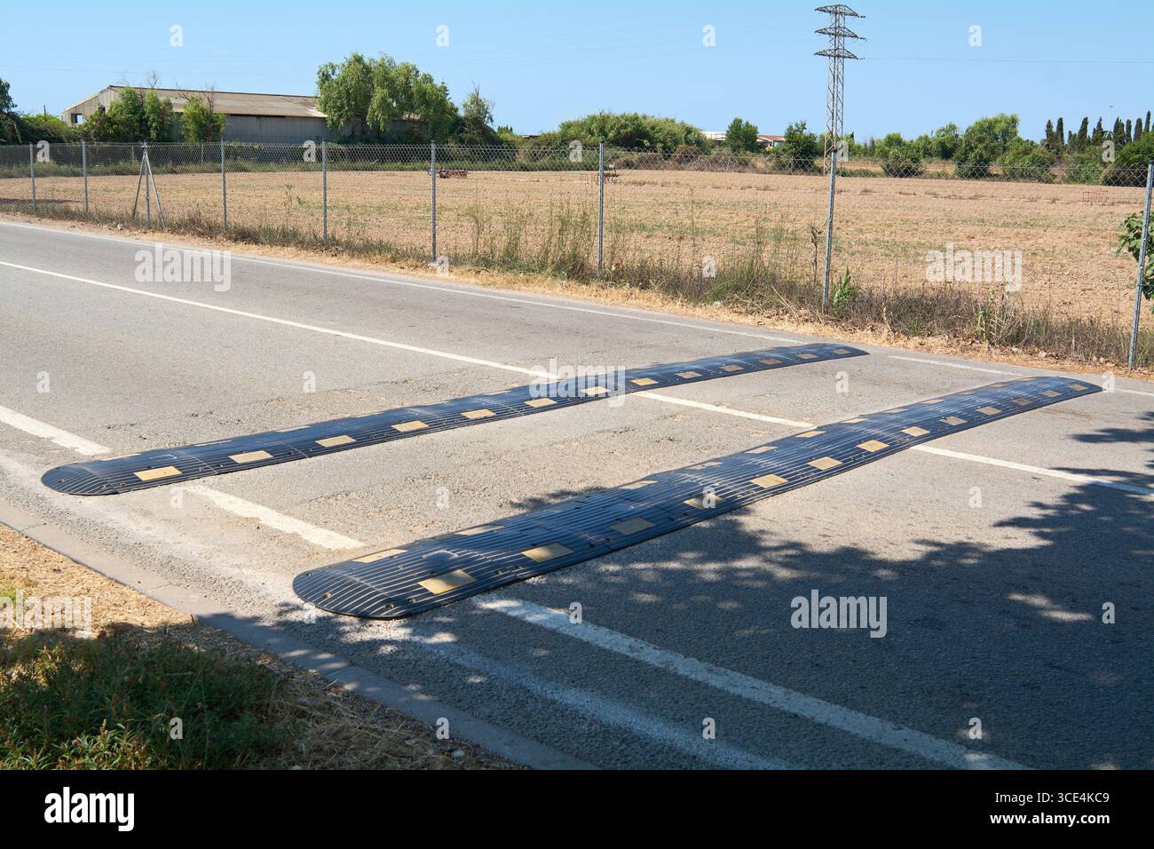 Un paio di riduttori di velocità su una strada secondaria. Rappresentano sicurezza, controllo e infrastrutture nella progettazione delle strade nelle aree rurali. Foto Stock