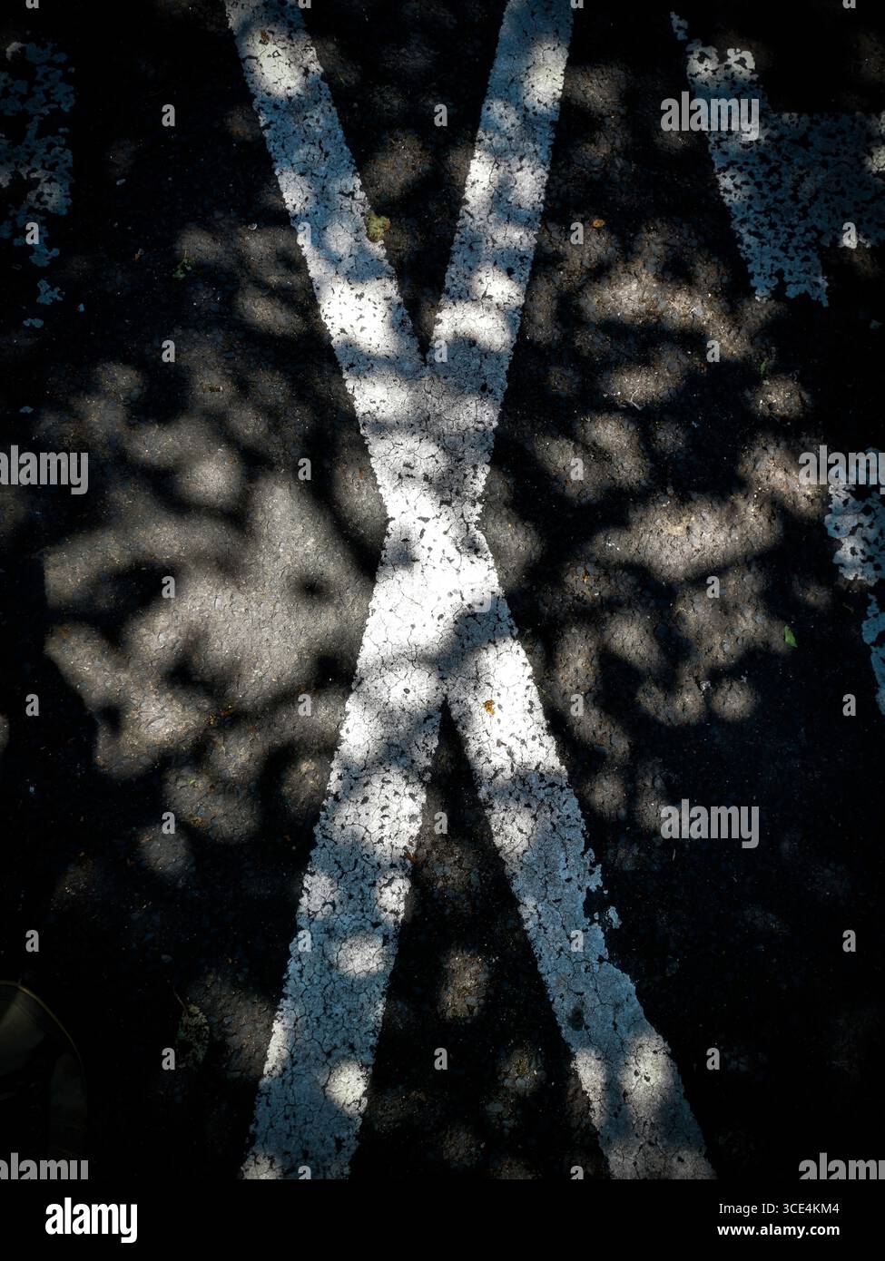 Attraversamento di strade bianche con segnali stradali e luce solare attenuata all'incrocio rurale Foto Stock
