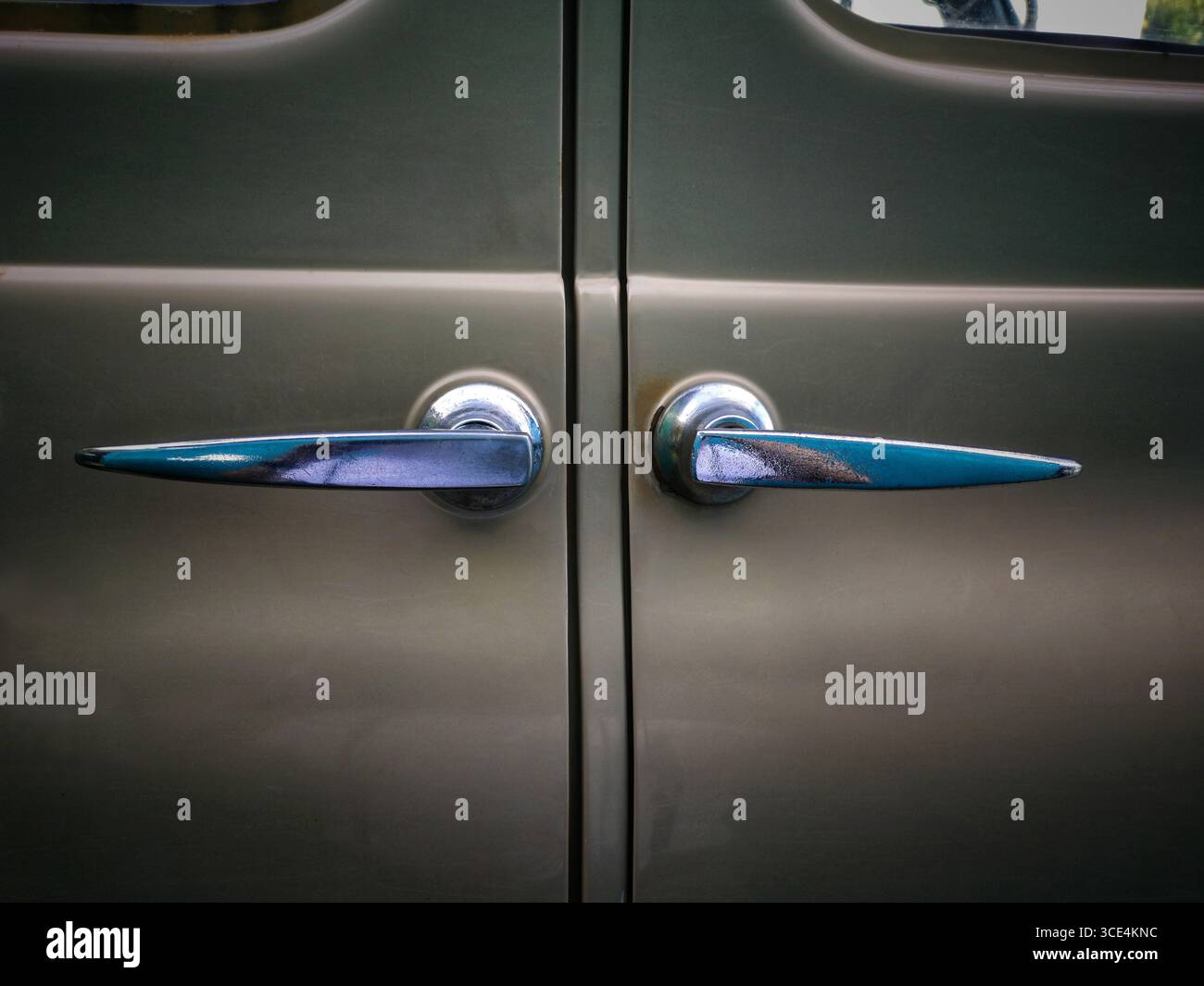 Vista ravvicinata delle due maniglie delle portiere di un'auto d'epoca che rivelano una brillante brillantezza metallizzata e un design unico. Foto Stock