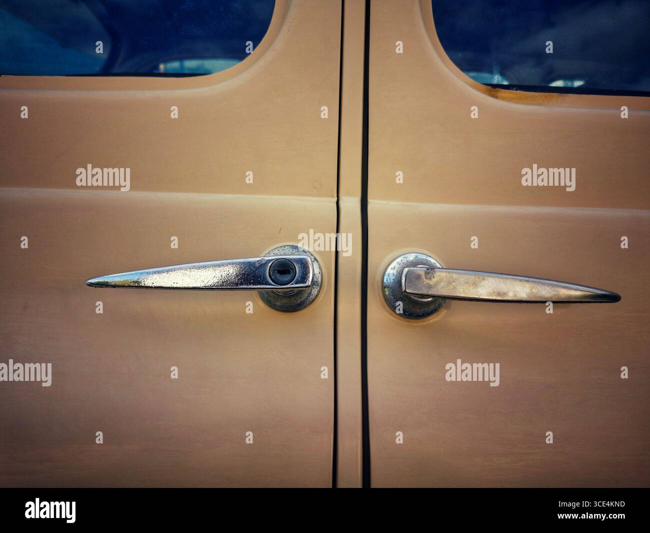 Vista ravvicinata delle due maniglie delle portiere di un'auto d'epoca che rivelano una brillante brillantezza metallizzata e un design unico. Foto Stock