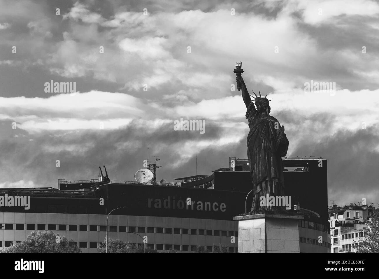 PARIGI, FRANCIA - 10 NOVEMBRE 2018: Statua della libertà a Parigi e edificio radio France sullo sfondo. Concetto di libertà di parola. Foto in bianco e nero. Foto Stock