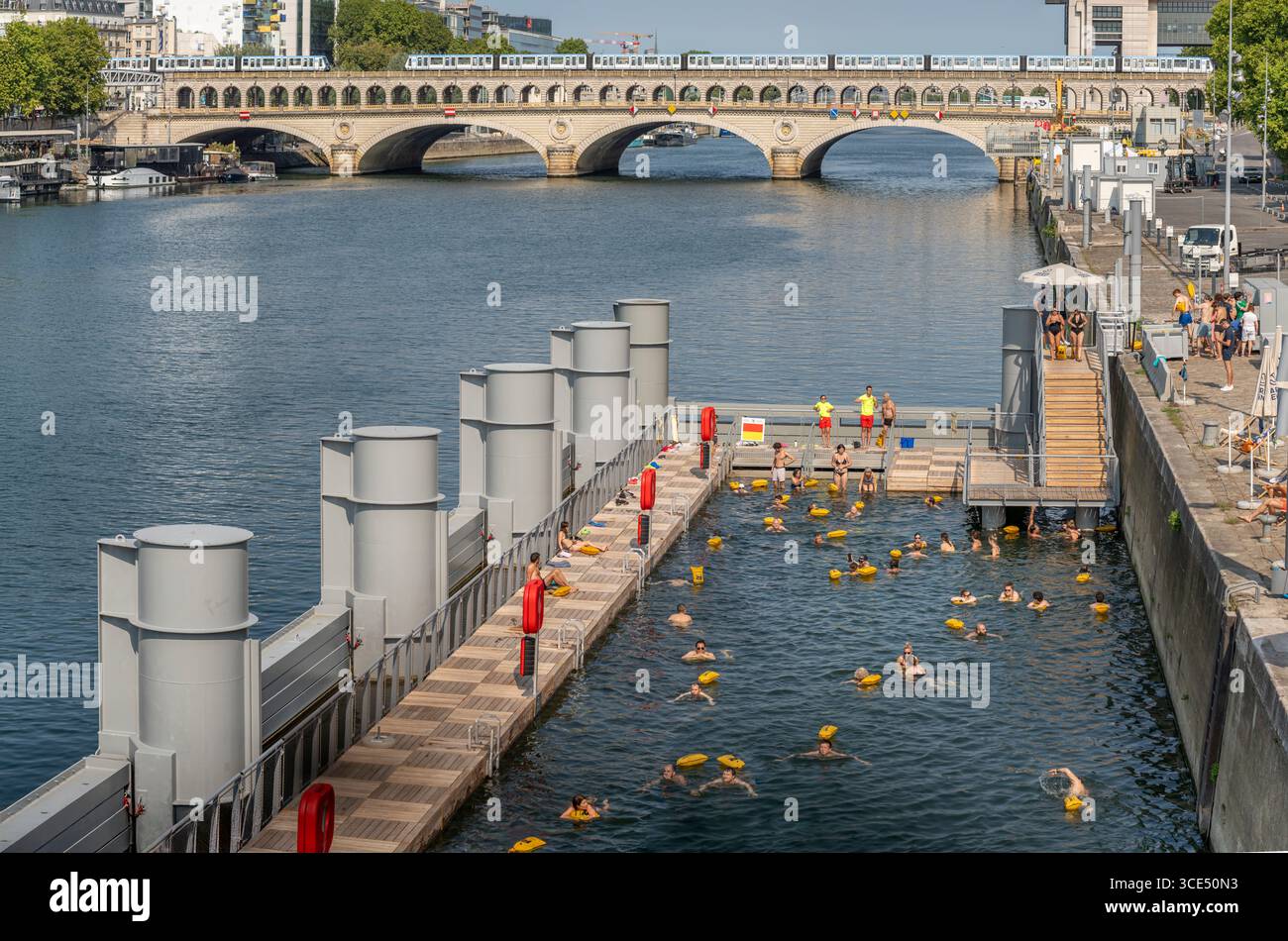 Parigi, Francia - 08 15 2025: Vista panoramica del nuoto estivo sulla Senna al molo di Bercy dal ponte pedonale Simone de Beauvoir Foto Stock