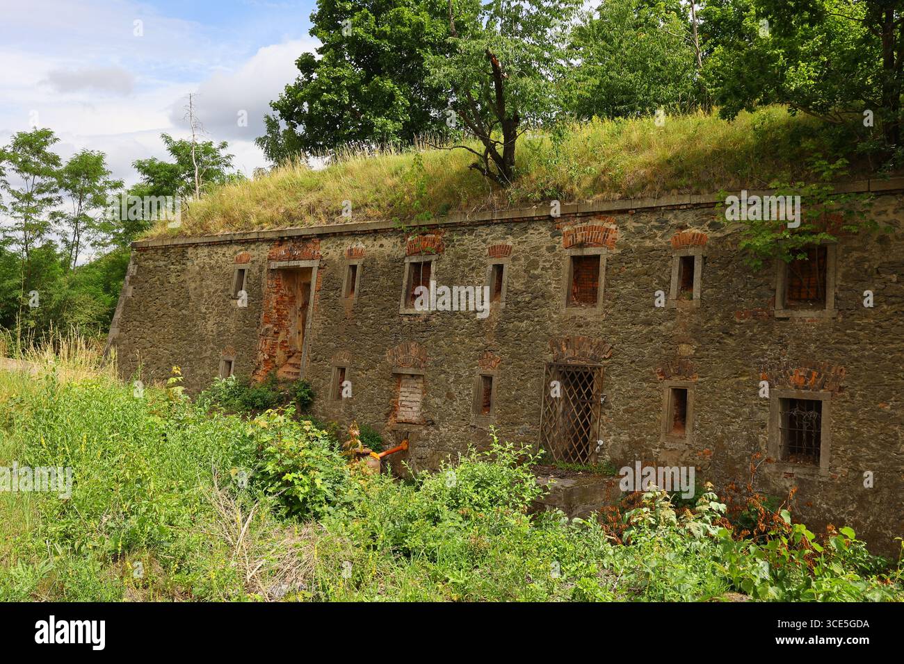Mura di pietra sovrastate della fortezza di Owcza Góra con piccole finestre a chiocciola e tetti erbosi a Kłodzko, Polonia Foto Stock