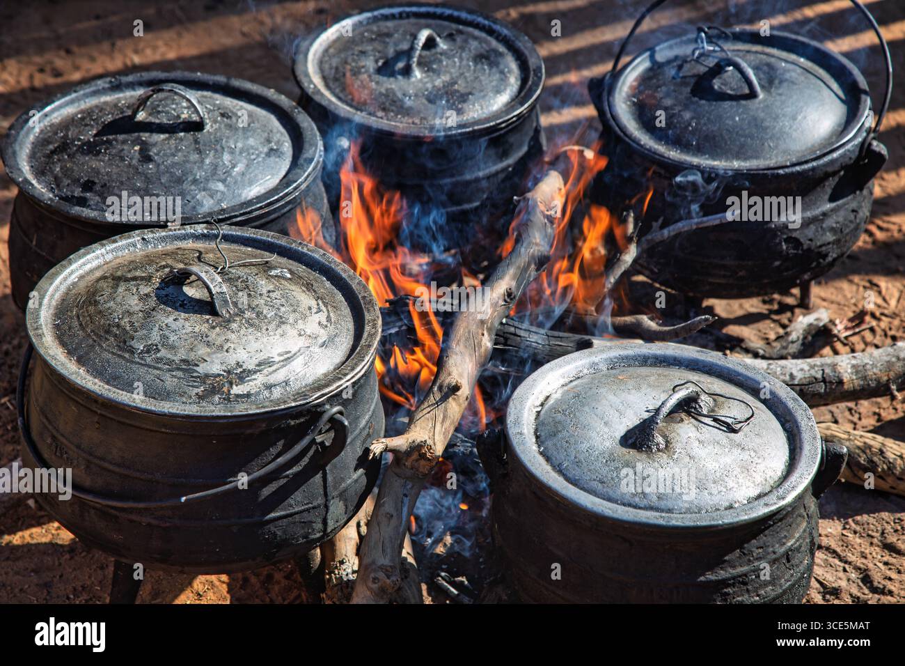 Calderone a tre zampe , cucina all'aperto , villaggio africano , in occasione di un evento, sicurezza alimentare nelle zone rurali Foto Stock