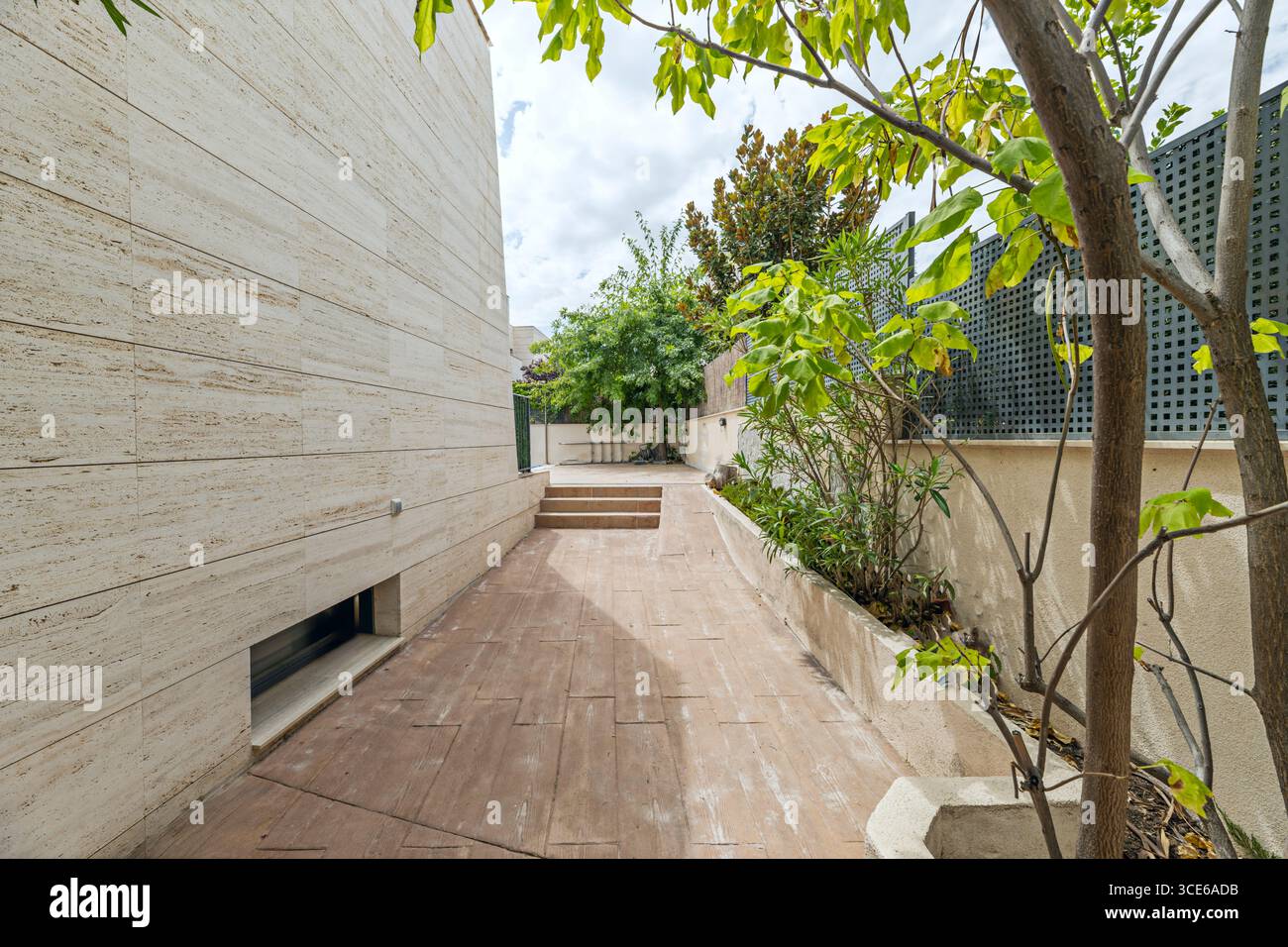 Casa singola di design con una facciata in marmo bianco sporco e un passaggio pedonale circostante con illuminazione a soffitto Foto Stock