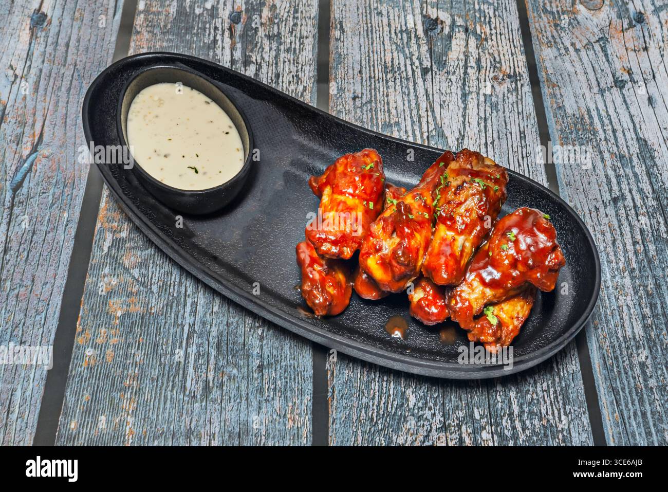 Ali di pollo in stile coreano fritti con glassa con salsa gochujang dolce e piccante, guarnite con semi di sesamo. Foto Stock