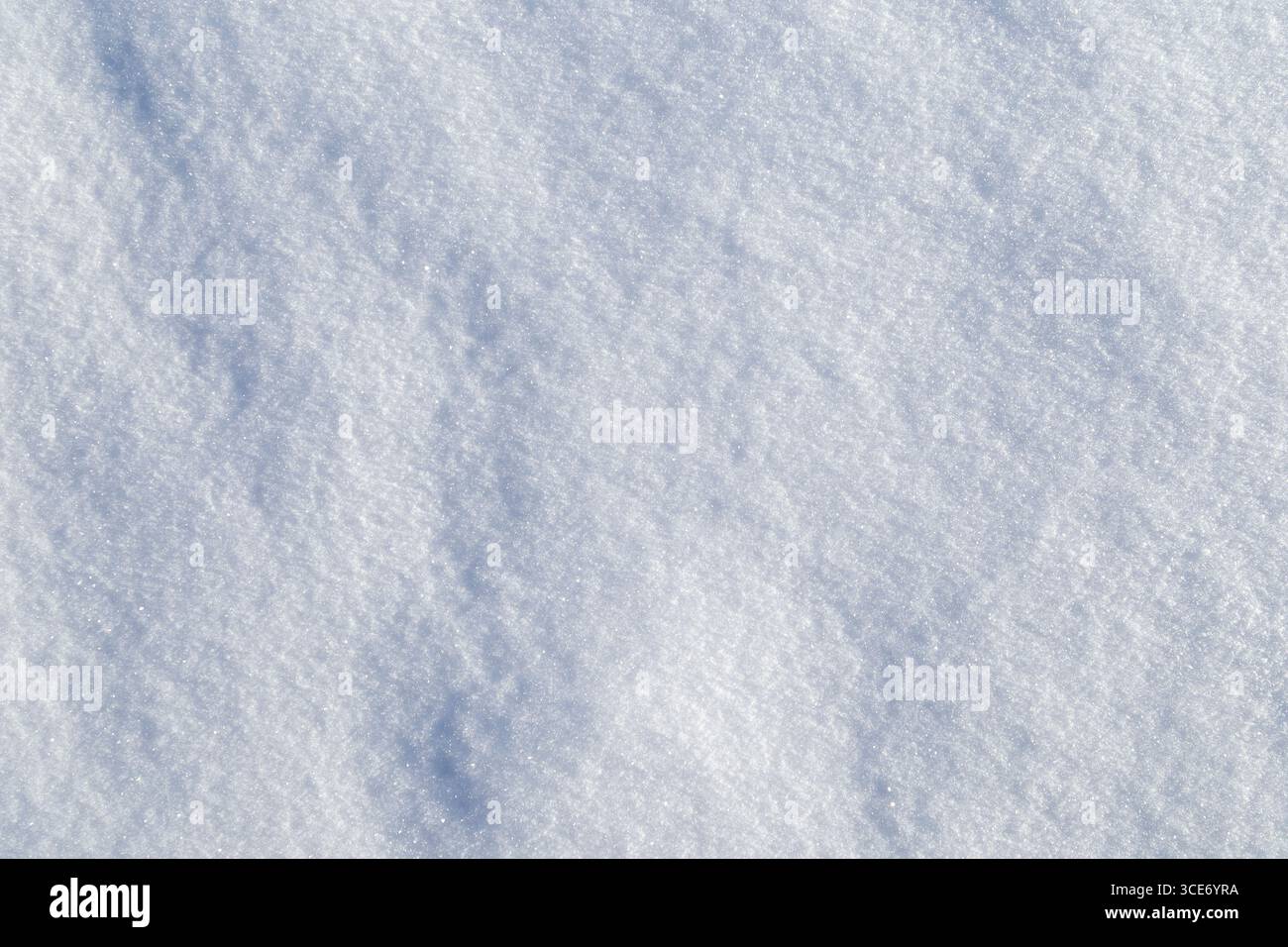 Primo piano di una fresca e luminosa terra innevata in inverno in una giornata di sole, vista dall'alto. Sfondo strutturato astratto con spazio di copia. Vista dall'alto. Foto Stock