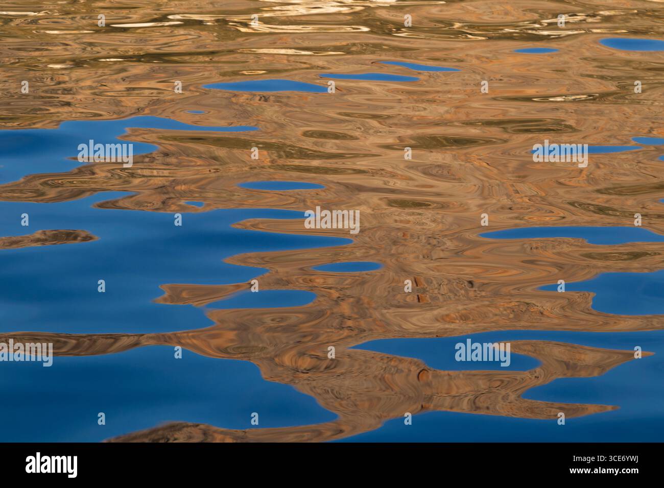 Riflessi astratti blu e marrone sulla superficie dell'acqua increspata. Sfondo dalle forme astratte naturali e dai colori vivaci. Foto Stock