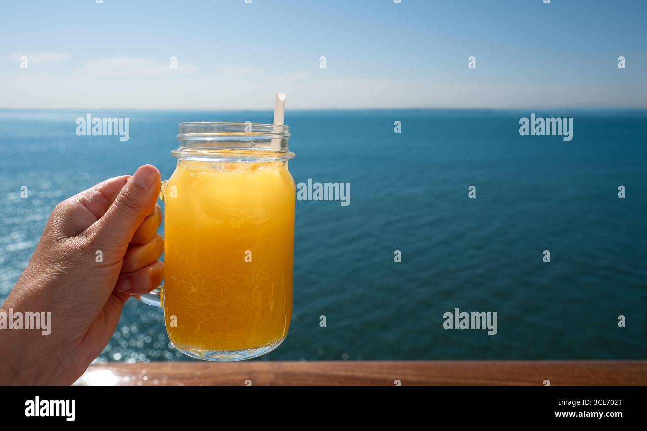 Succo d'arancia rinfrescante al mare. Foto Stock