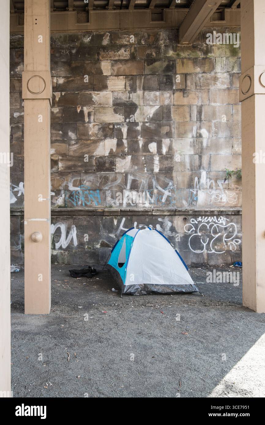 Senzatetto e che vive in una tenda vicino al ponte di alto livello a Newcastle. Foto Stock