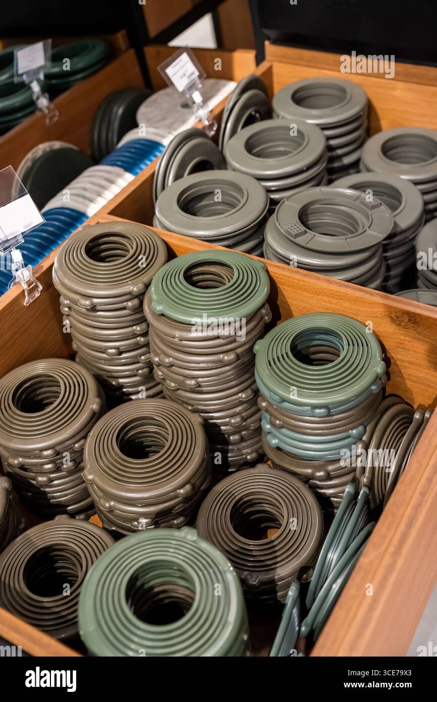 Pile di anelli di rivestimento rotondi in plastica per l'installazione a soffitto allungato, utilizzati per fissare e rifinire le aperture per gli impianti di illuminazione incassati. Foto Stock