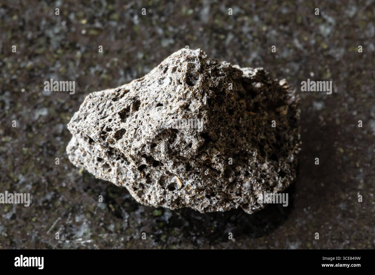 Assaggio di pietra lavica pomice grezza su sfondo di granito nero da vicino dalla Sicilia Foto Stock