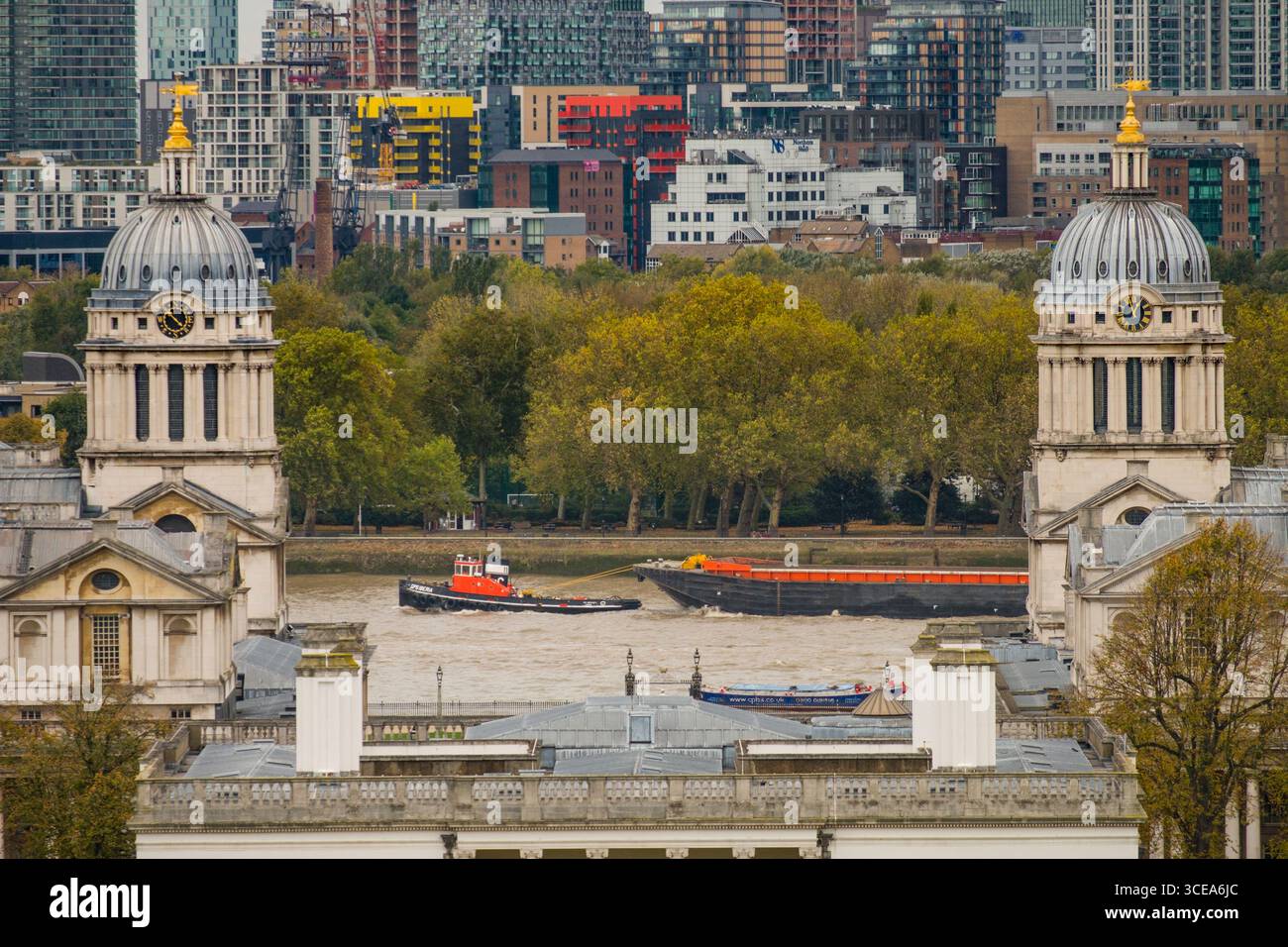 Il GPS Iberia nave cargo (HAZ-d) chiatta di traino fino al Fiume Tamigi visibile tra la Old Royal Naval College di edifici da Greenwich Park, Greenwich, Lond Foto Stock