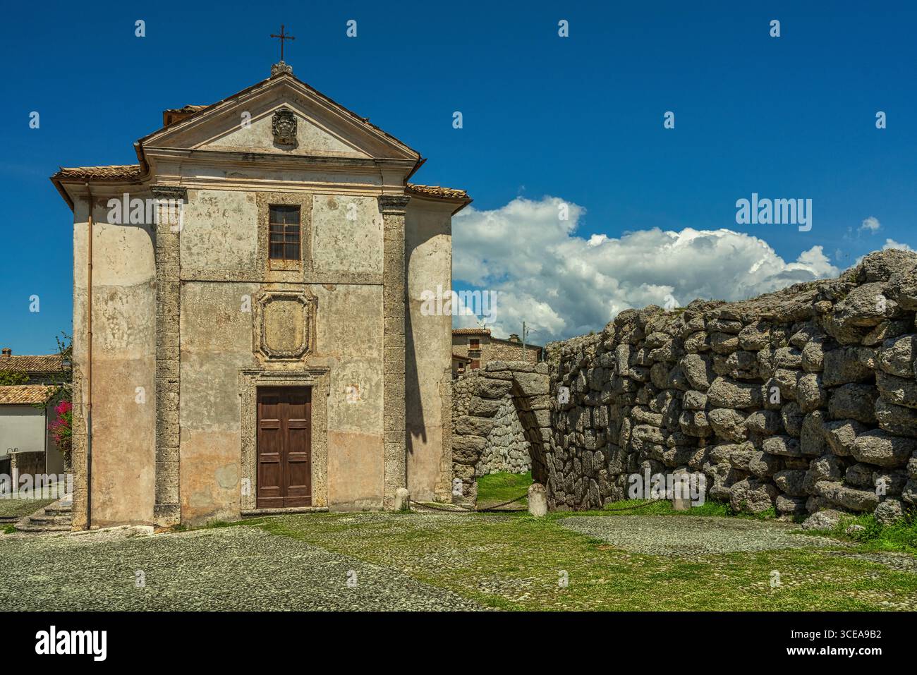 La Chiesa della Santissima Trinità nell'antica Acropoli di Arpino, Civitavecchia, racchiusa all'interno di mura poligonali con la porta SCEA ad arco appuntito. Foto Stock