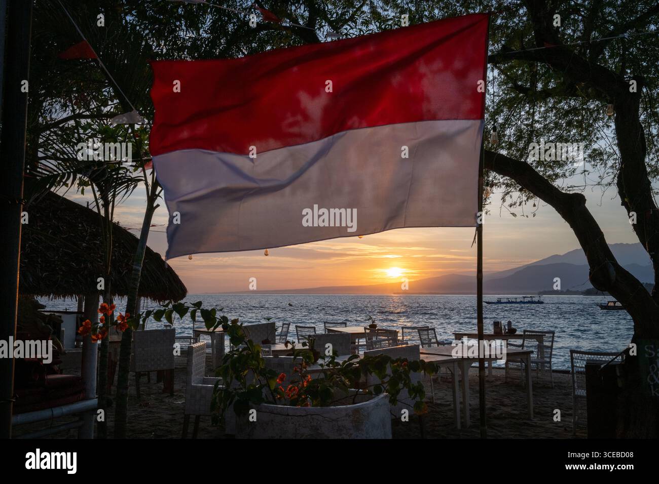 Gili Air, Indonesia, 17 agosto 2025. Una bandiera indonesiana fluttua nel vento mentre il sole sorge la mattina del 80° giorno dell'indipendenza indonesiana. Il giorno dell’indipendenza indonesiana è una festa pubblica in Indonesia che viene celebrata il 17 agosto di ogni anno e segna l’indipendenza dell’Indonesia dal dominio coloniale olandese. Crediti: Scott Ramsey Photography/Alamy Live News Foto Stock
