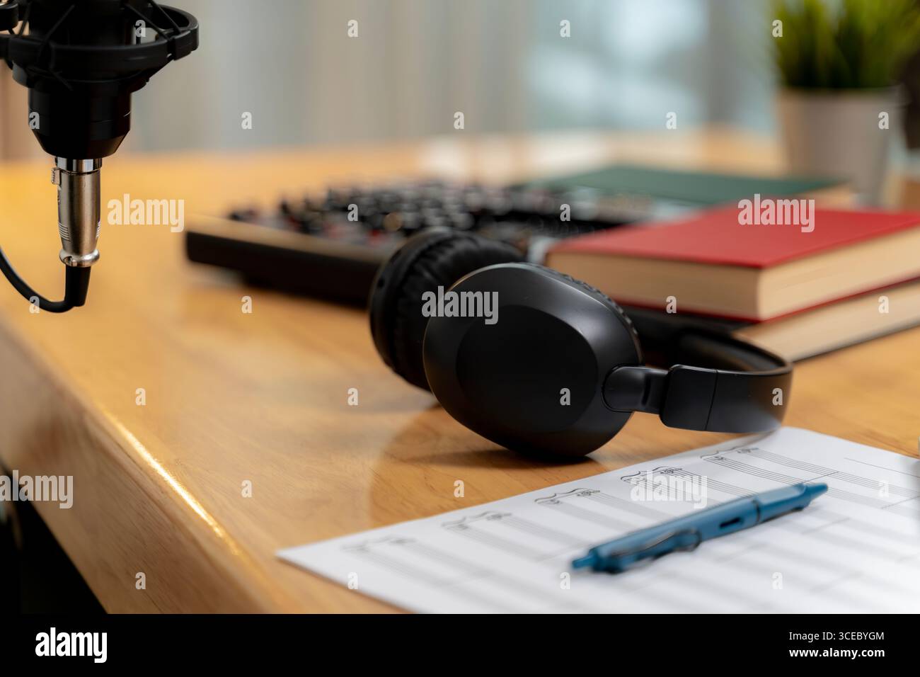 Un'area di lavoro creativa per la registrazione di podcast con microfono, cuffie e configurazione da scrivania, che simboleggia la produzione e la comunicazione di contenuti multimediali digitali. Foto Stock