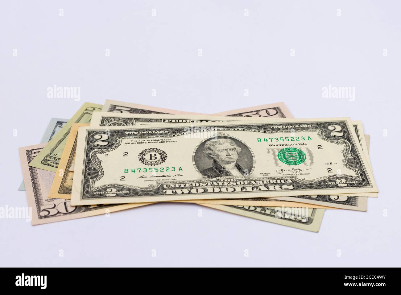 Primo piano delle banconote in dollari statunitensi diffuse su sfondo bianco Foto Stock