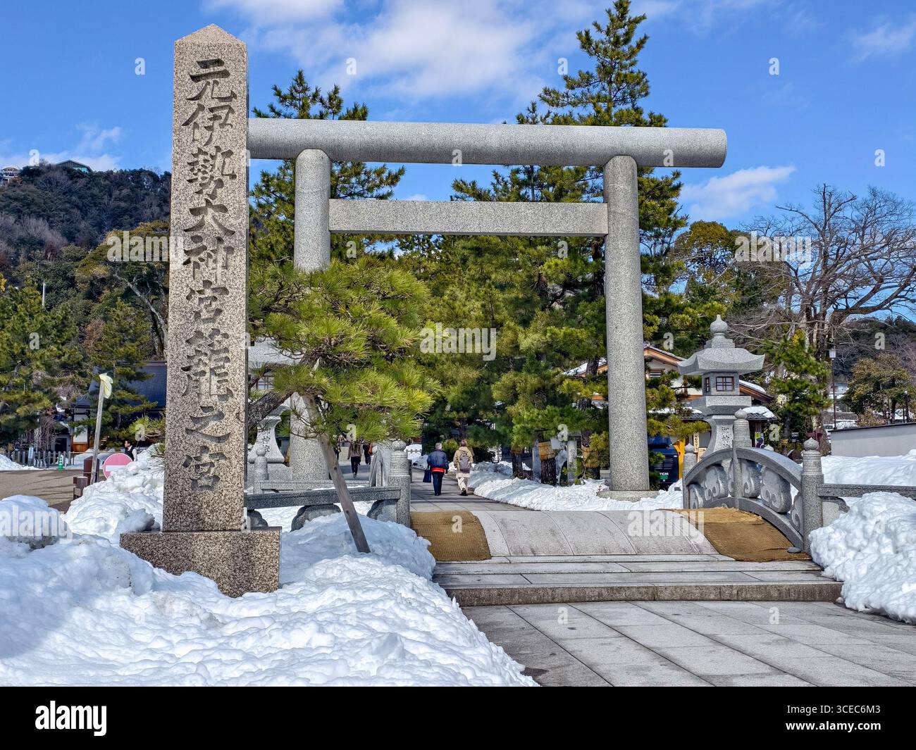 La grande porta torii in pietra che segna l'ingresso allo storico santuario Motoise Kono, un importante sito shintoista, coperto di neve fresca. Miyazu, Kyoto Foto Stock
