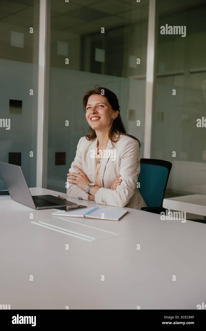 Una donna d'affari sicura che sorride in un moderno ambiente Office Space Foto Stock