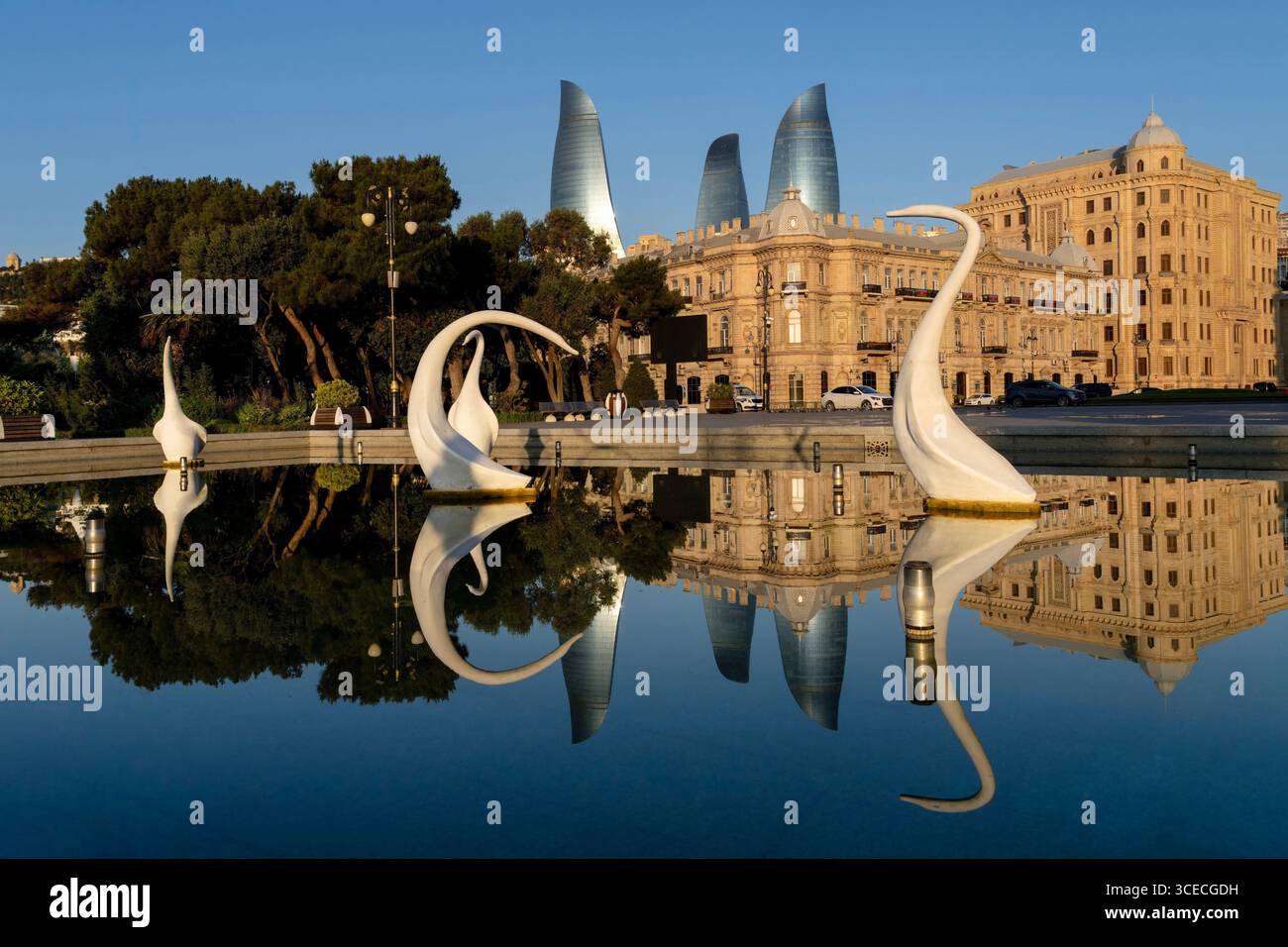Piscina con cigni e skyline di Baku con riflessi sull'acqua a Baku, Azerbaigian Foto Stock
