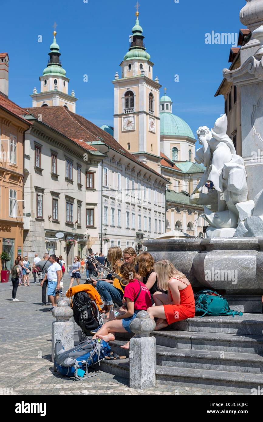 Lubiana, Slovenia - 15 agosto 2019: I giovani con la chitarra si rilassano sui gradini della fontana di Robb, il famoso scultore veneziano, fu costruito Foto Stock