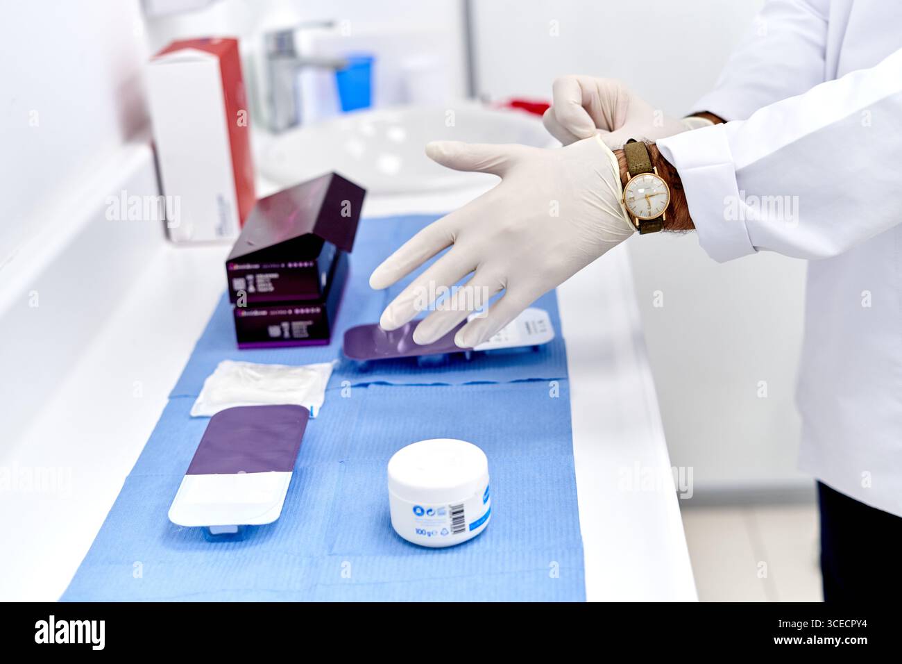 Primo piano di un professionista medico maschile che indossa guanti protettivi. Medico che indossa guanti protettivi in clinica Foto Stock