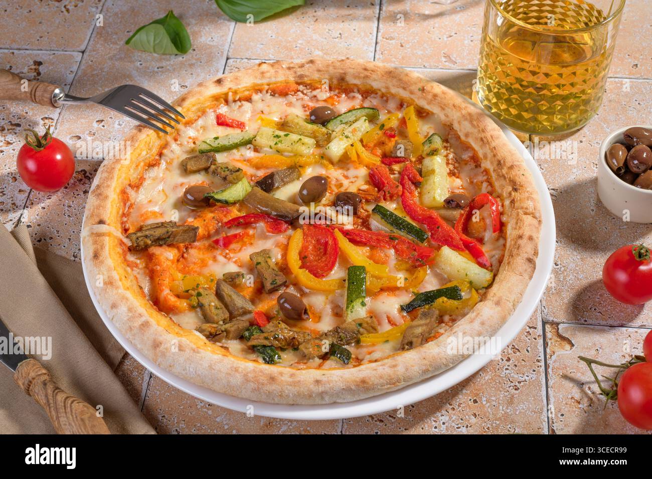 Una vivace pizza vegetariana condita con verdure fresche colorate, tra cui peperoni rossi e gialli, zucchine e olive, servita su un forno perfetto Foto Stock