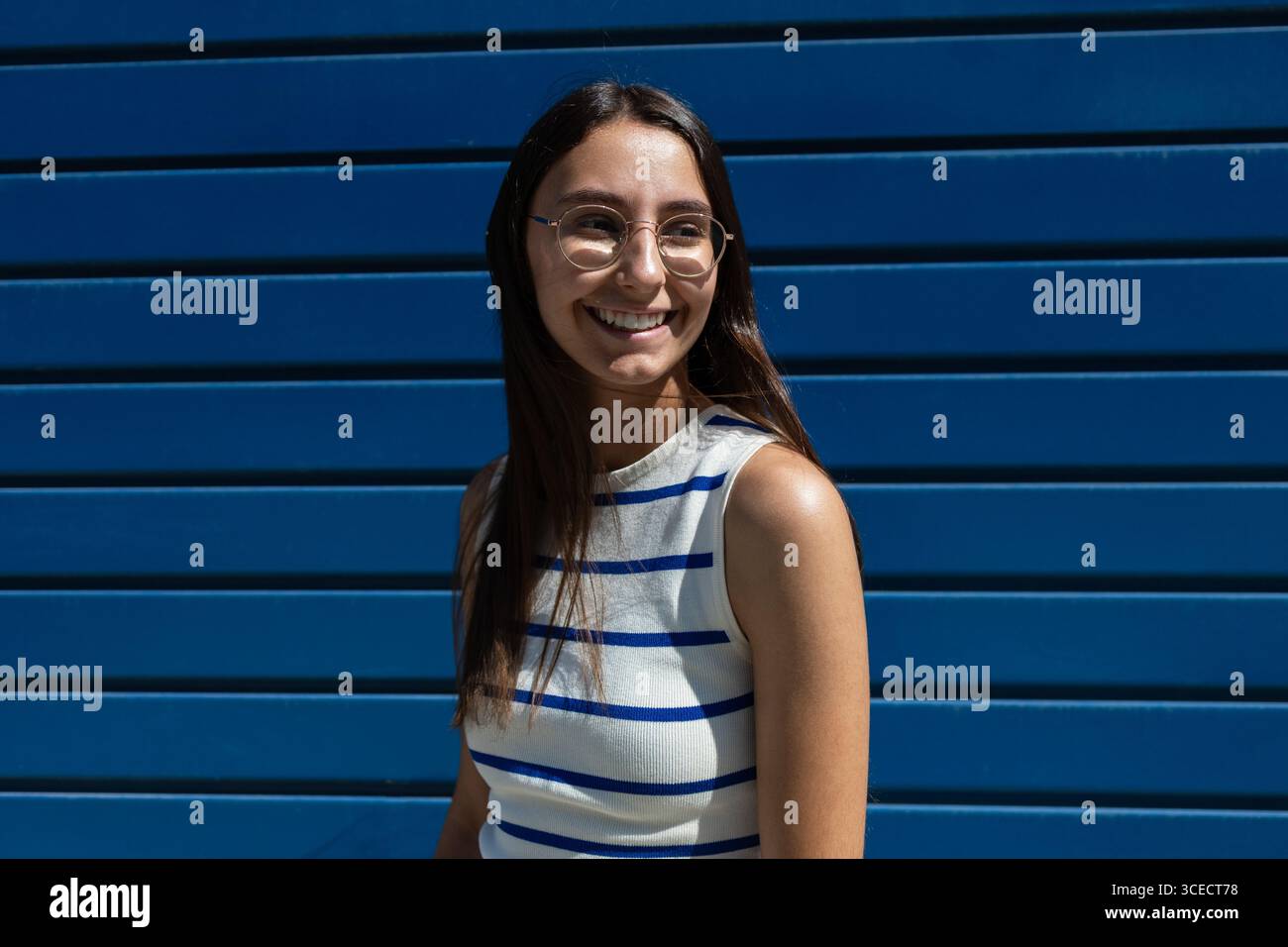 Una donna ama lo stile di vita urbano, incarnando la libertà e la vitalità della città. Il suo sorriso riflette un gioioso abbraccio dell'esperienza urbana all'aria aperta, b Foto Stock