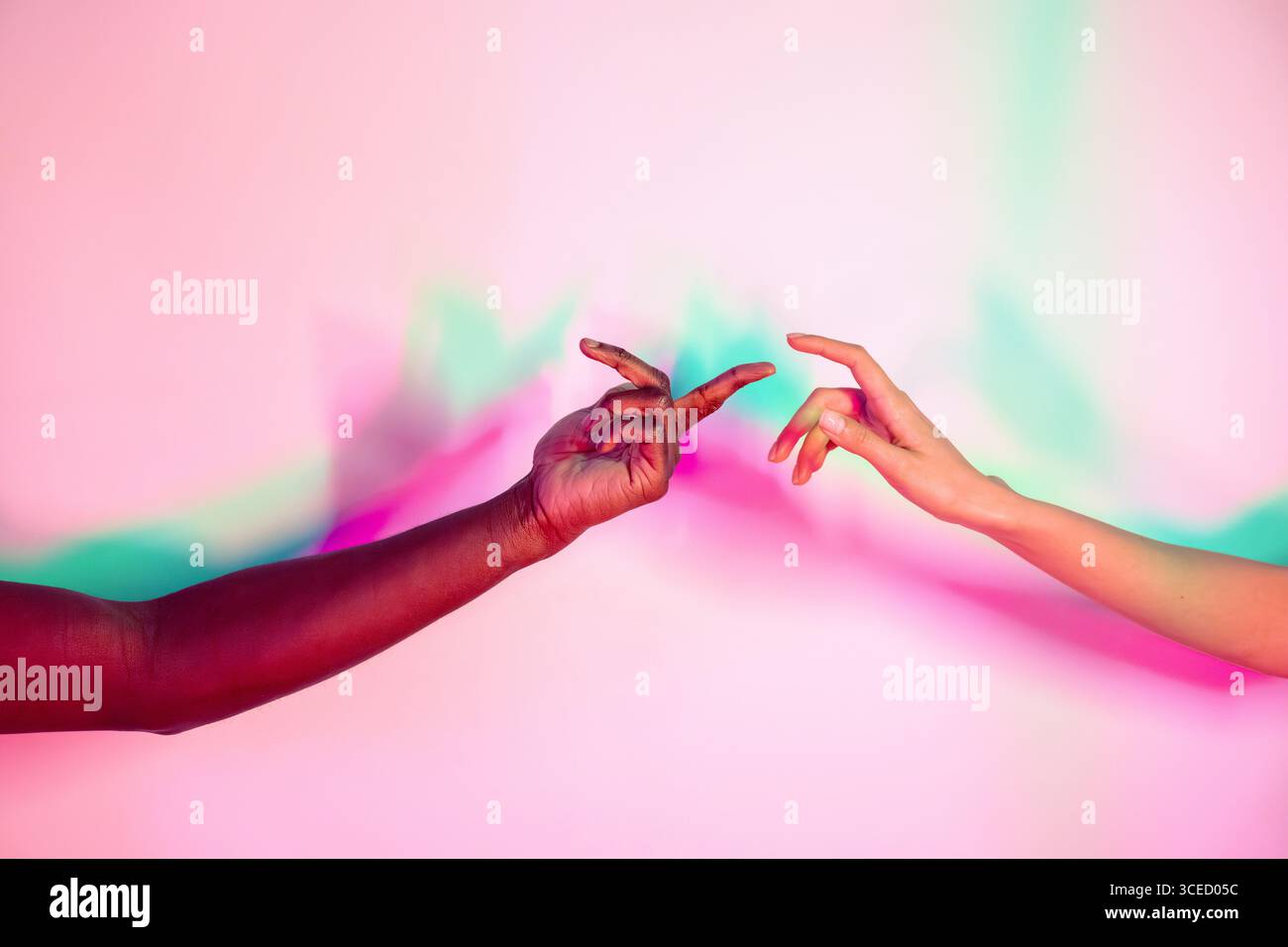 Due mani multietniche si estendono l'una verso l'altra su uno sfondo vivace e colorato. L'immagine simboleggia connessione, diversità e unità, Highligh Foto Stock