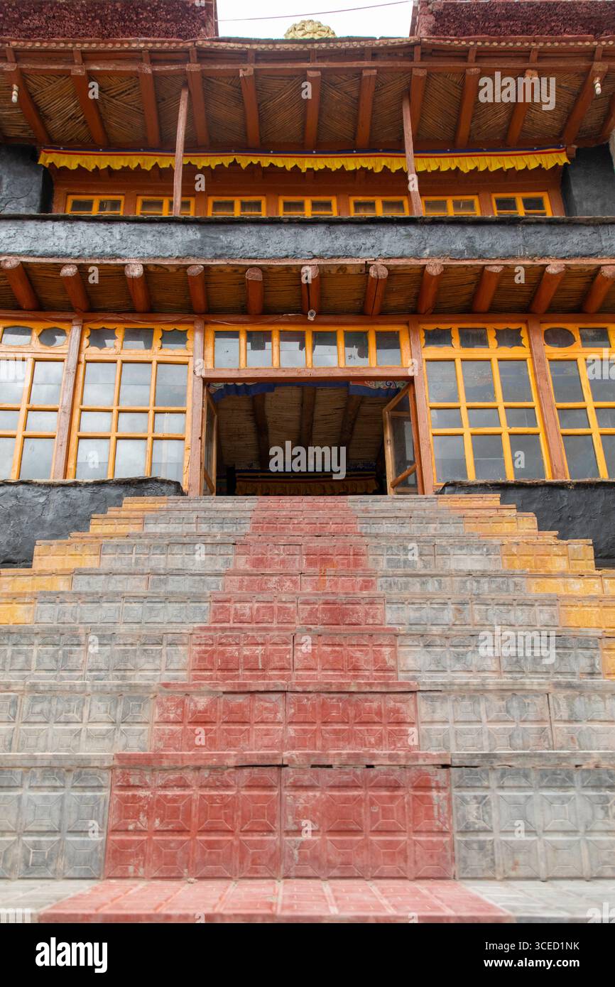 I gradini conducono ad un edificio tradizionale nella panoramica valle di Zanskar, Ladakh, India. Il design architettonico presenta colori vivaci ed elementi in legno Foto Stock